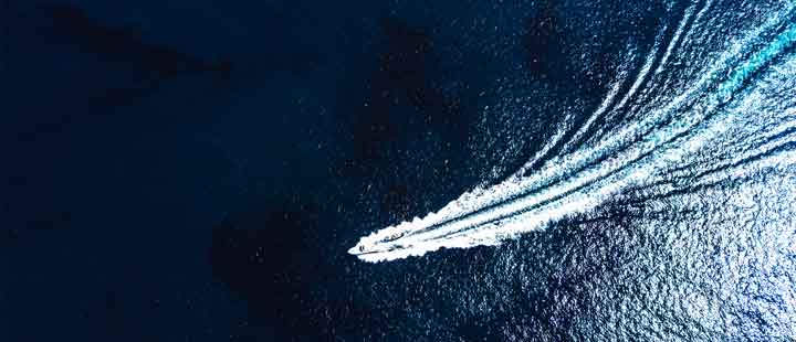 Sea Boat sealing in ocean view from above. Aerial view of moving boat or yacht in sea.